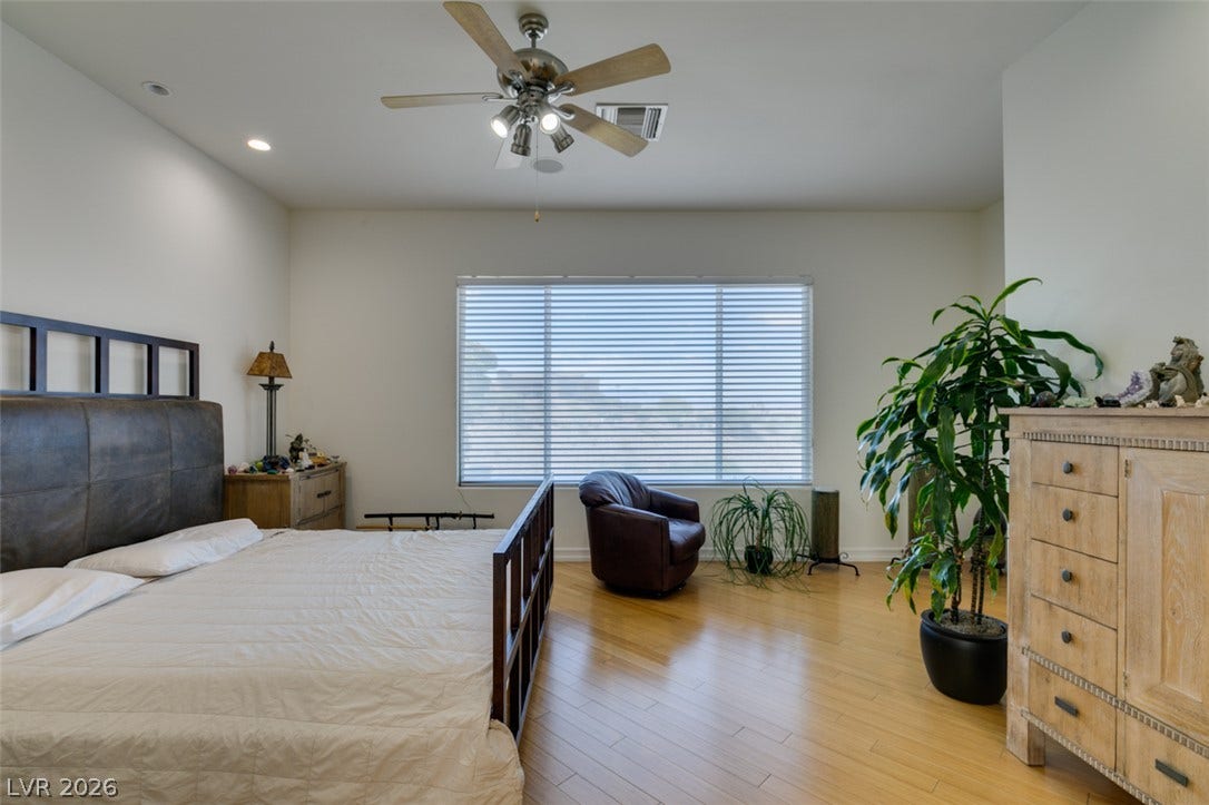 51 E Braelinn Drive, Henderson, NV 89052 Polished hardwood floors and generous natural light elevate this relaxing bedroom retreat.