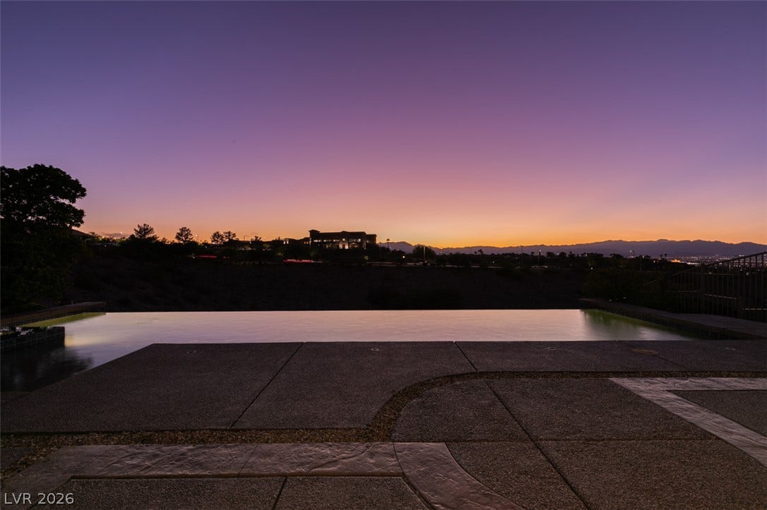51 E Braelinn Drive, Henderson, NV 89052 An infinity pool aligns with far-reaching mountain and city skyline views during sunset.