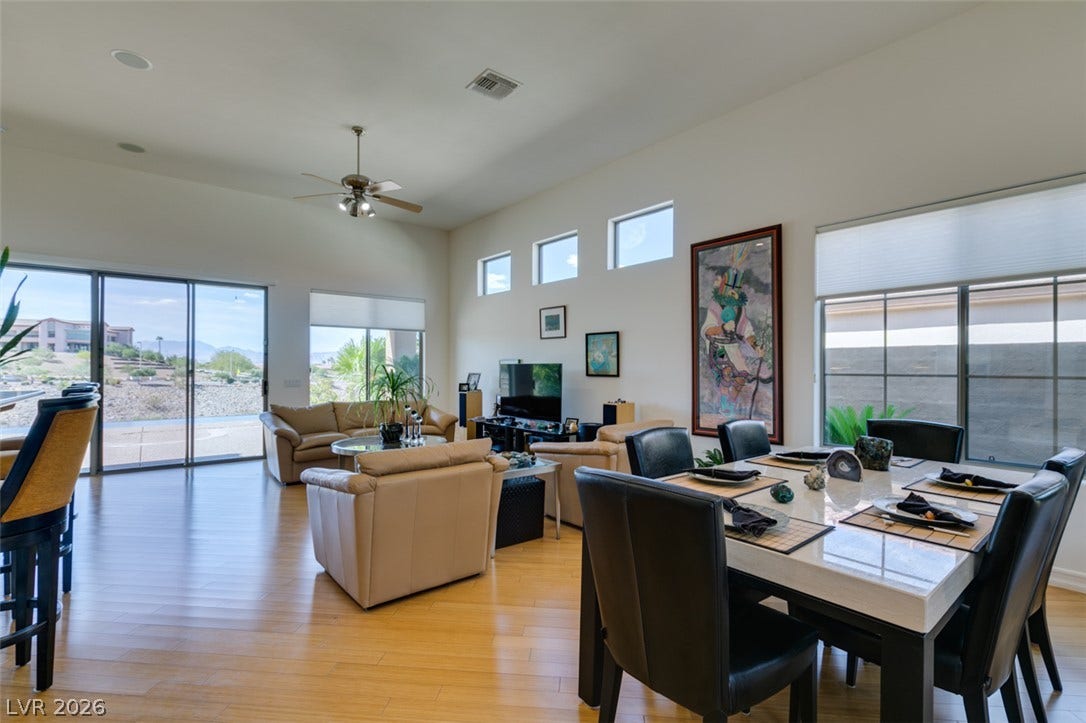 51 E Braelinn Drive, Henderson, NV 89052 An open dining and living area features high ceilings and sliding glass doors.