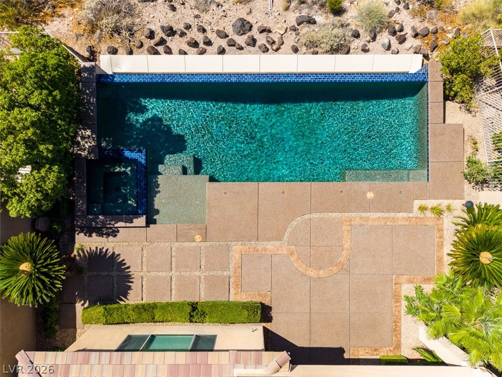 51 E Braelinn Drive, Henderson, NV 89052 A geometric swimming pool and custom concrete patio shine in this aerial backyard view.
