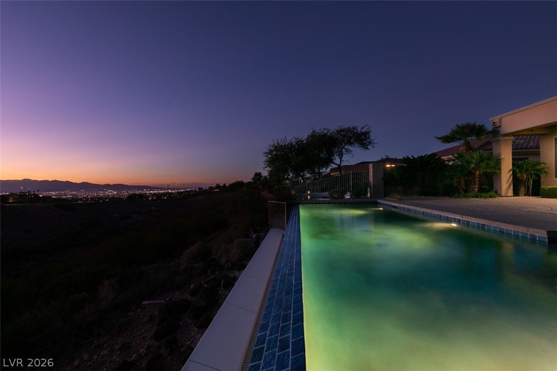 51 E Braelinn Drive, Henderson, NV 89052 Glistening pool waters overlook far-reaching city lights and mountain horizons at sunset.