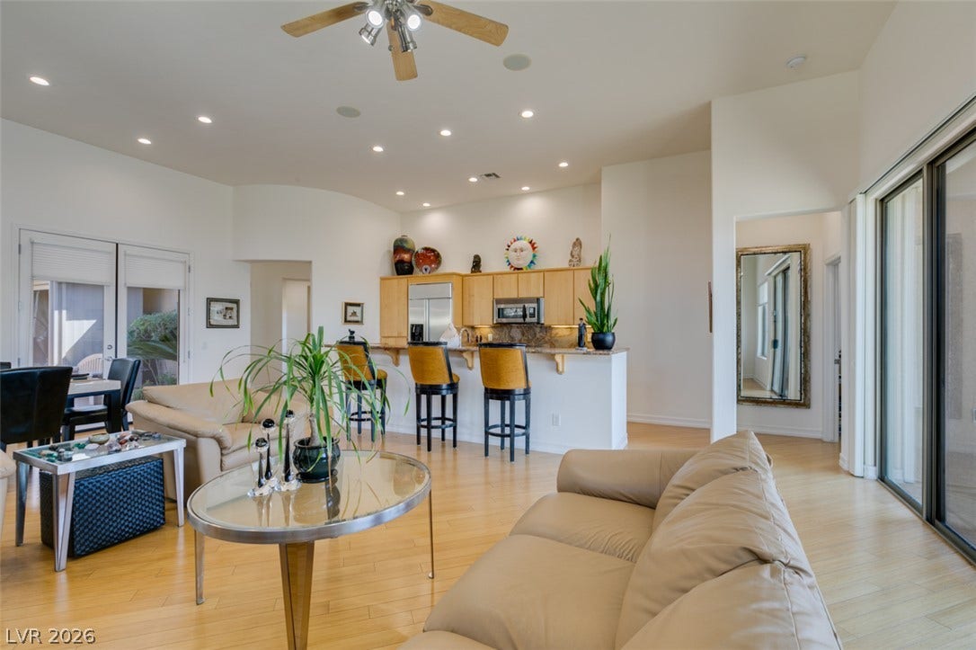 51 E Braelinn Drive, Henderson, NV 89052 Recessed lighting illuminates this open living space featuring wood flooring and sliding glass doors.