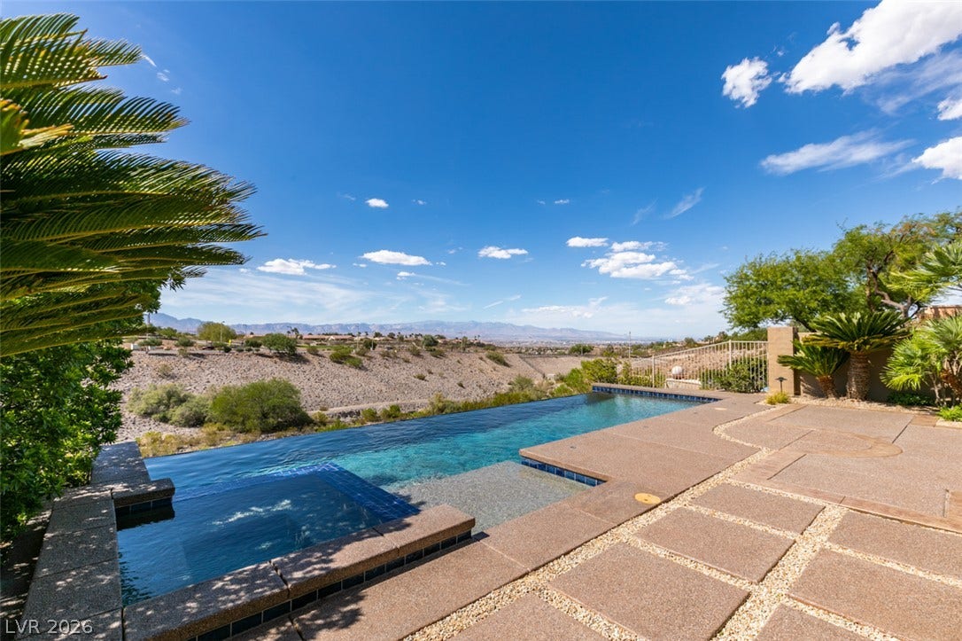 51 E Braelinn Drive, Henderson, NV 89052 An inviting infinity pool and spa overlook panoramic mountain vistas under clear desert skies.