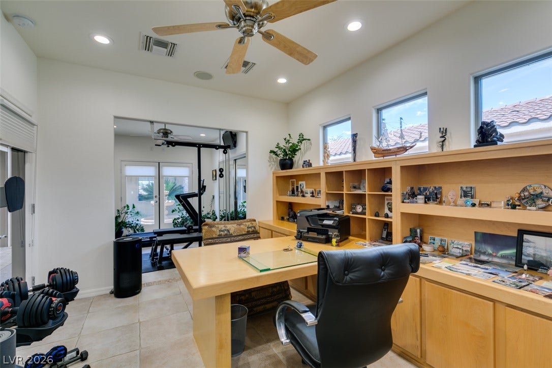 51 E Braelinn Drive, Henderson, NV 89052 A spacious home office offers tiled flooring, built-in wooden shelving, and high recessed lighting ceilings.