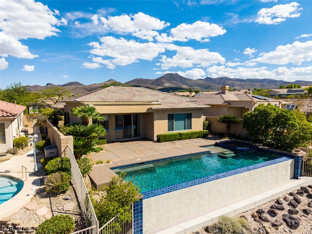 51 E Braelinn Drive, Henderson, NV 89052 An inviting backyard pool overlooks dramatic mountain ridges under a vast desert sky.