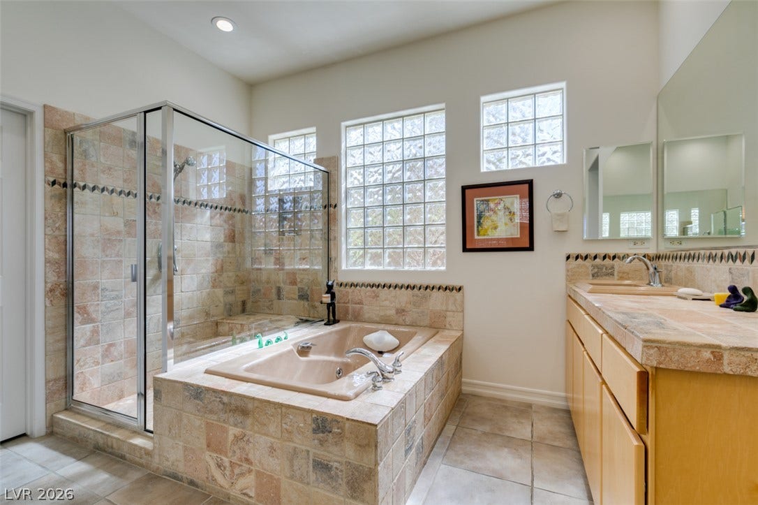 51 E Braelinn Drive, Henderson, NV 89052 A glass-enclosed shower, built-in soaking tub, and tile finishes highlight this primary bath.
