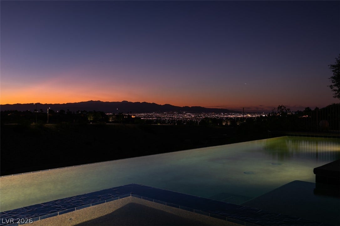 51 E Braelinn Drive, Henderson, NV 89052 Glimmering city lights and distant mountains frame the edge of a sleek infinity pool.
