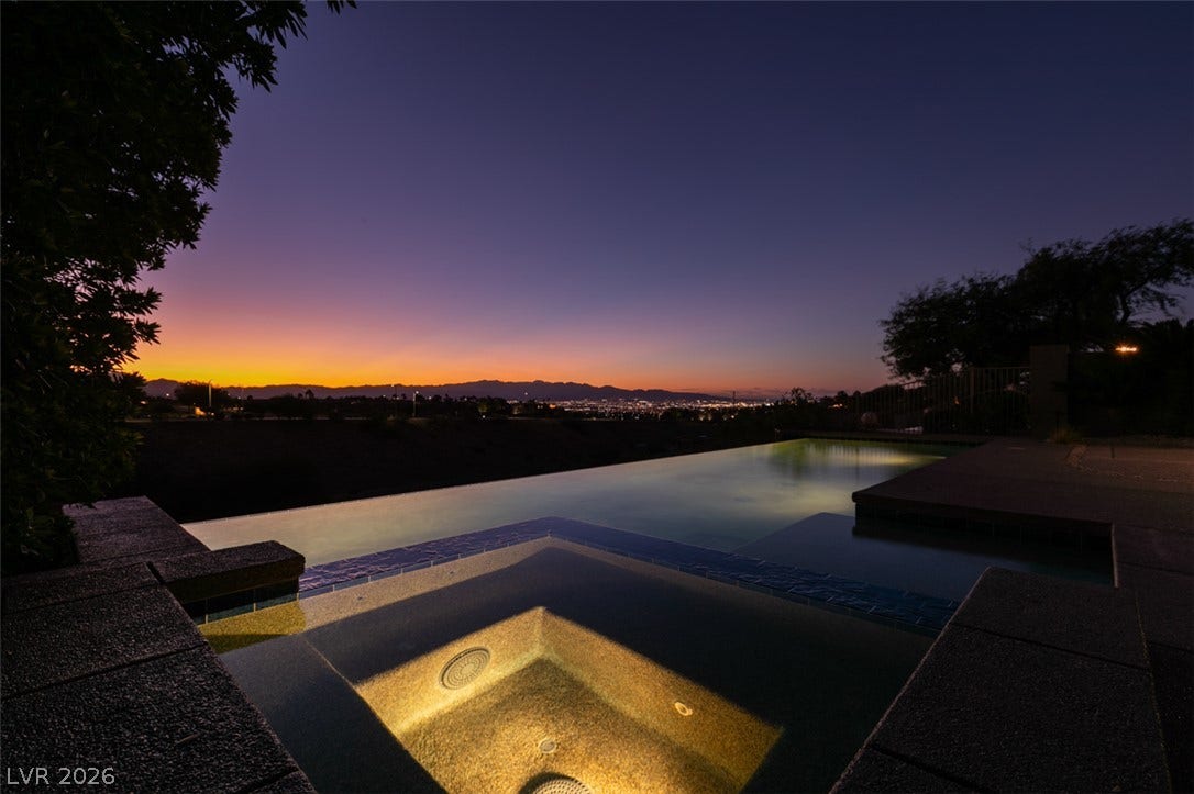 51 E Braelinn Drive, Henderson, NV 89052 An infinity pool and spa overlook glowing city lights framed by twilight skies.