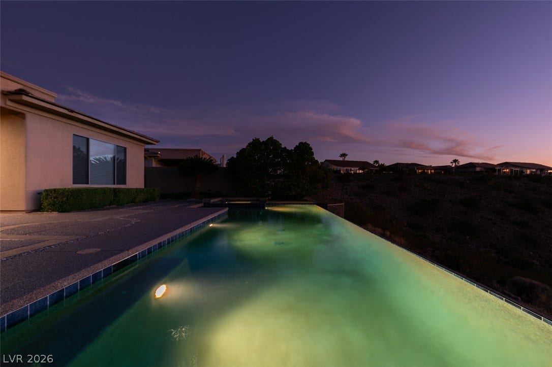 51 E Braelinn Drive, Henderson, NV 89052 A sparkling infinity pool overlooks serene twilight views and hillside homes.