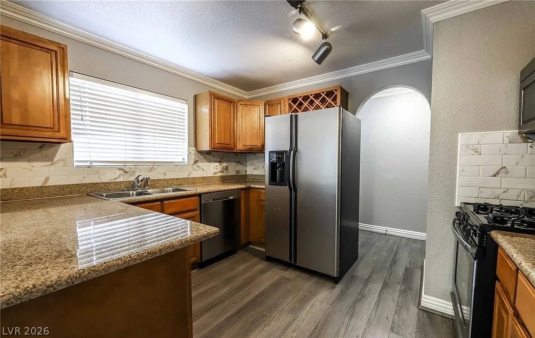 2700 N Rainbow Boulevard, #2137, Las Vegas, NV 89108 Granite countertops, crown molding, and a classic arched doorway define this functional cooking space.