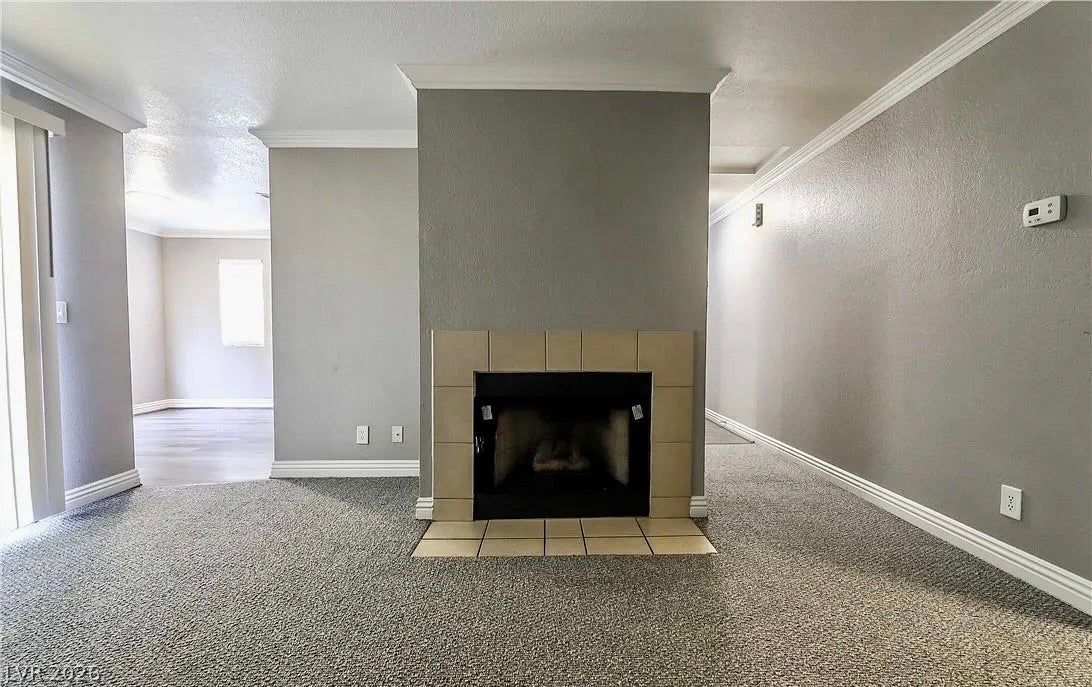 2700 N Rainbow Boulevard, #2137, Las Vegas, NV 89108 Crown molding frames a central tiled fireplace in an open living space with neutral tones.