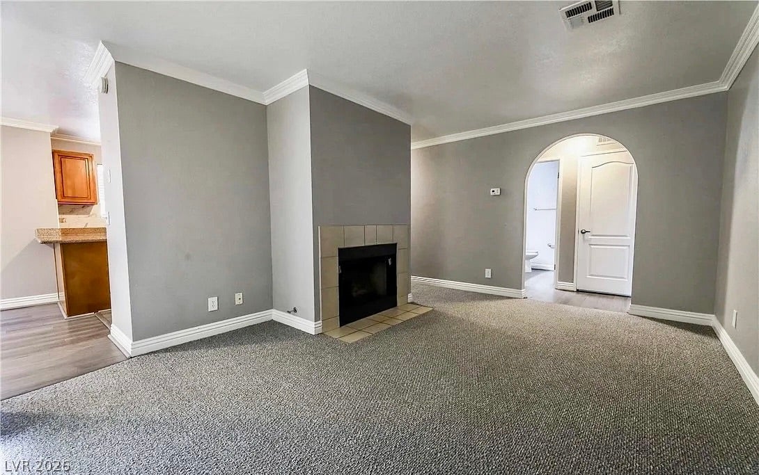 2700 N Rainbow Boulevard, #2137, Las Vegas, NV 89108 Crown molding and a classic tiled fireplace enhance this carpeted living space.