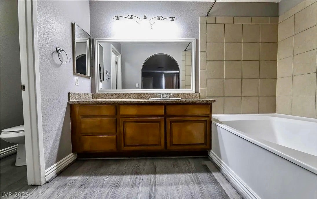 2700 N Rainbow Boulevard, #2137, Las Vegas, NV 89108 Tiled walls frame the soaking tub alongside a wood vanity with granite counters.