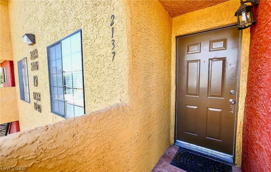 2700 N Rainbow Boulevard, #2137, Las Vegas, NV 89108 A private entrance framed by textured stucco walls welcomes guests to the home.