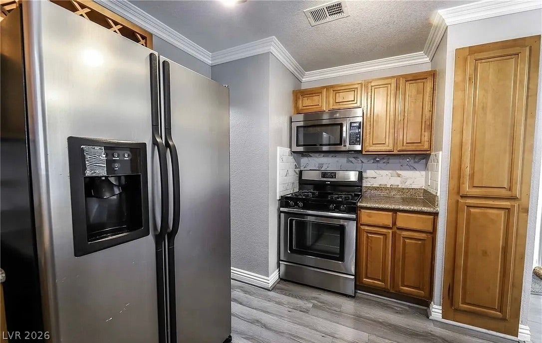 2700 N Rainbow Boulevard, #2137, Las Vegas, NV 89108 Gleaming stainless steel appliances complement the warm wood cabinetry and detailed crown molding.