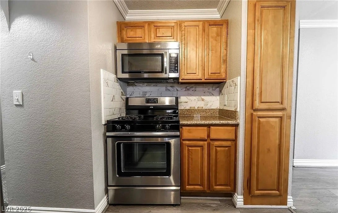 2700 N Rainbow Boulevard, #2137, Las Vegas, NV 89108 Rich wood cabinetry contrasts beautifully with granite countertops and modern stainless steel appliances.