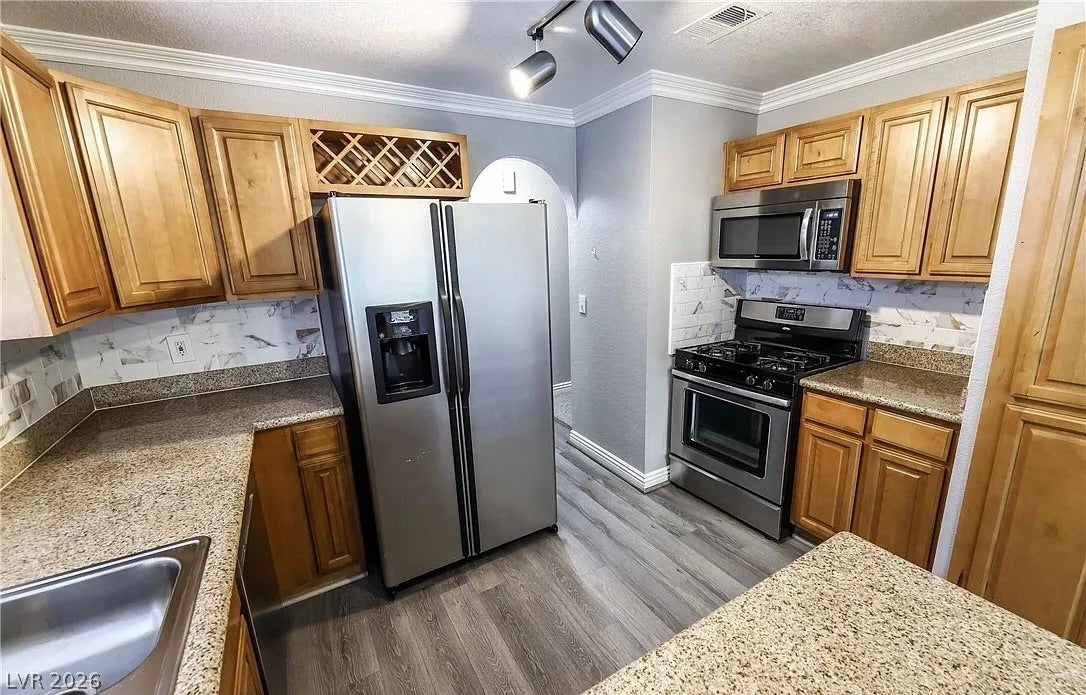 2700 N Rainbow Boulevard, #2137, Las Vegas, NV 89108 Crown molding and warm wood cabinetry define this kitchen designed with granite countertops.