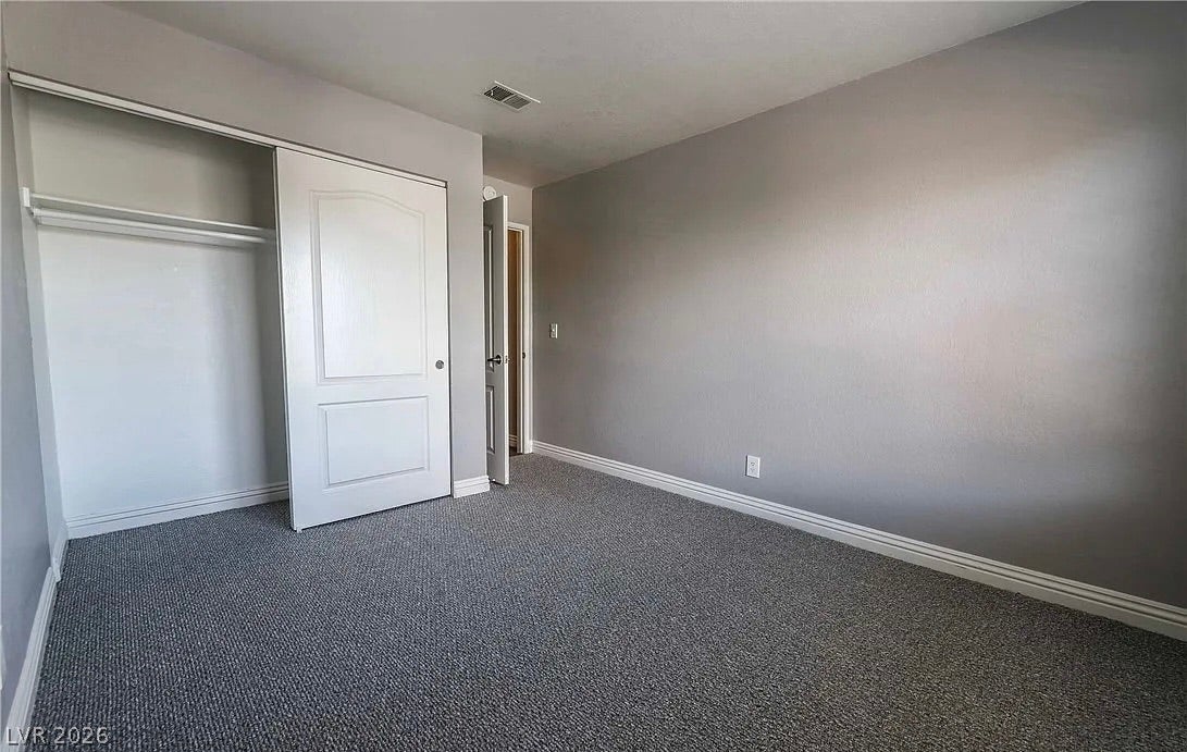 2700 N Rainbow Boulevard, #2137, Las Vegas, NV 89108 Smooth walls and classic baseboards frame a quiet bedroom featuring carpet flooring and built-in closet storage.