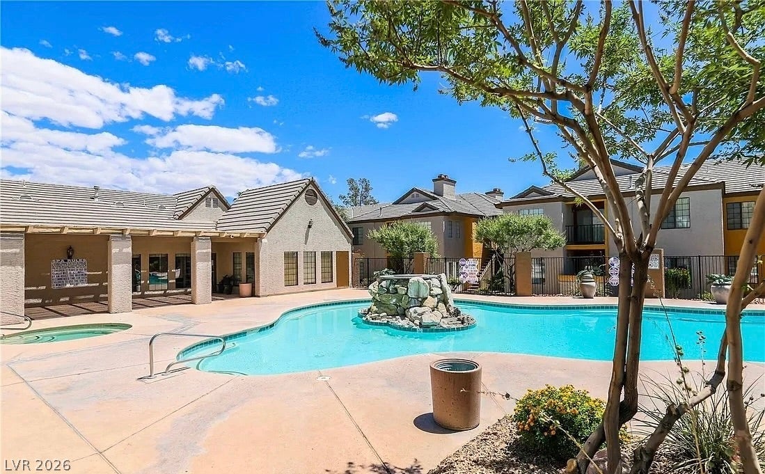 2700 N Rainbow Boulevard, #2137, Las Vegas, NV 89108 An inviting swimming pool features a stone water fountain surrounded by paved sun lounging areas.