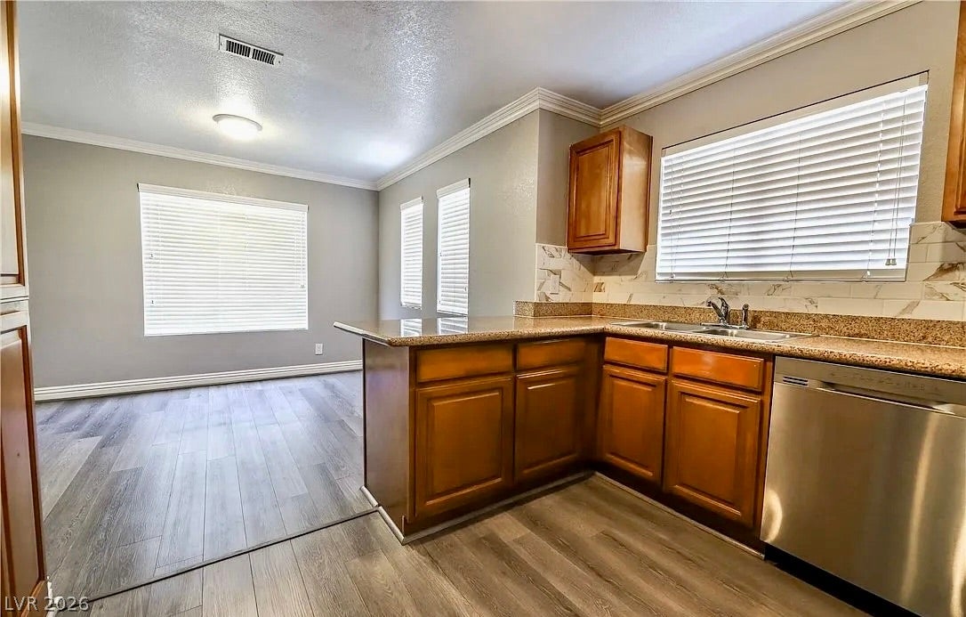2700 N Rainbow Boulevard, #2137, Las Vegas, NV 89108 Hardwood floors and classic crown molding elevate this open-concept kitchen and dining area.
