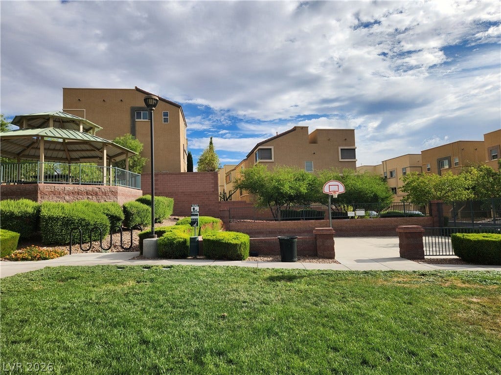 10549 Gibbous Moon Drive, Las Vegas, NV 89129 A spacious green lawn sits adjacent to community basketball areas under a bright sky.