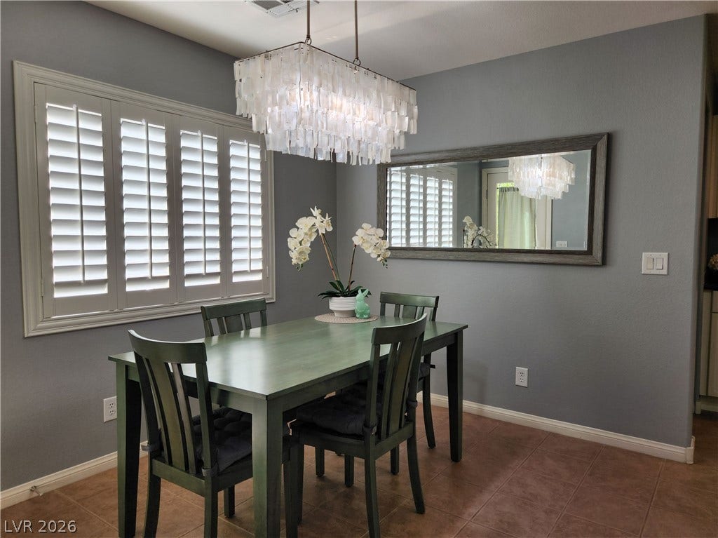 10549 Gibbous Moon Drive, Las Vegas, NV 89129 Plantation shutters and modern tile flooring define this inviting dining room space.