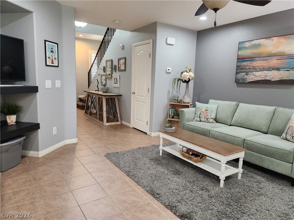 10549 Gibbous Moon Drive, Las Vegas, NV 89129 Tiled flooring flows through this inviting living area featuring built-in media shelving.