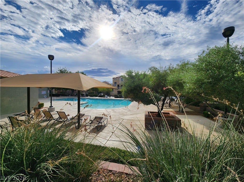 10549 Gibbous Moon Drive, Las Vegas, NV 89129 An inviting swimming pool area sits surrounded by concrete decking under sunny skies.