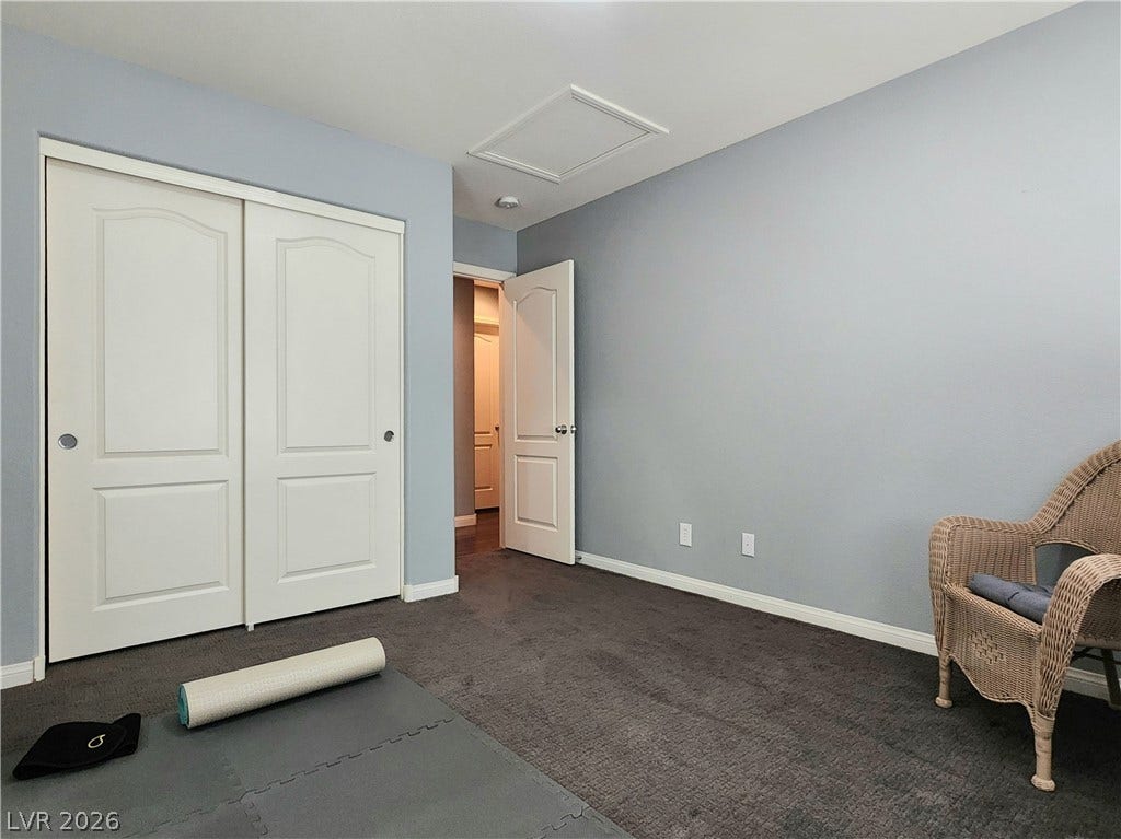 10549 Gibbous Moon Drive, Las Vegas, NV 89129 Grey walls and wall-to-wall carpeting define this versatile secondary room.