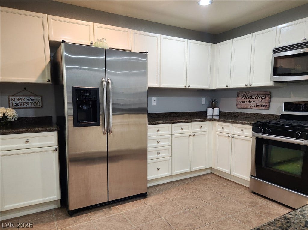 10549 Gibbous Moon Drive, Las Vegas, NV 89129 Ample cabinetry and durable tile flooring define this functional kitchen space.