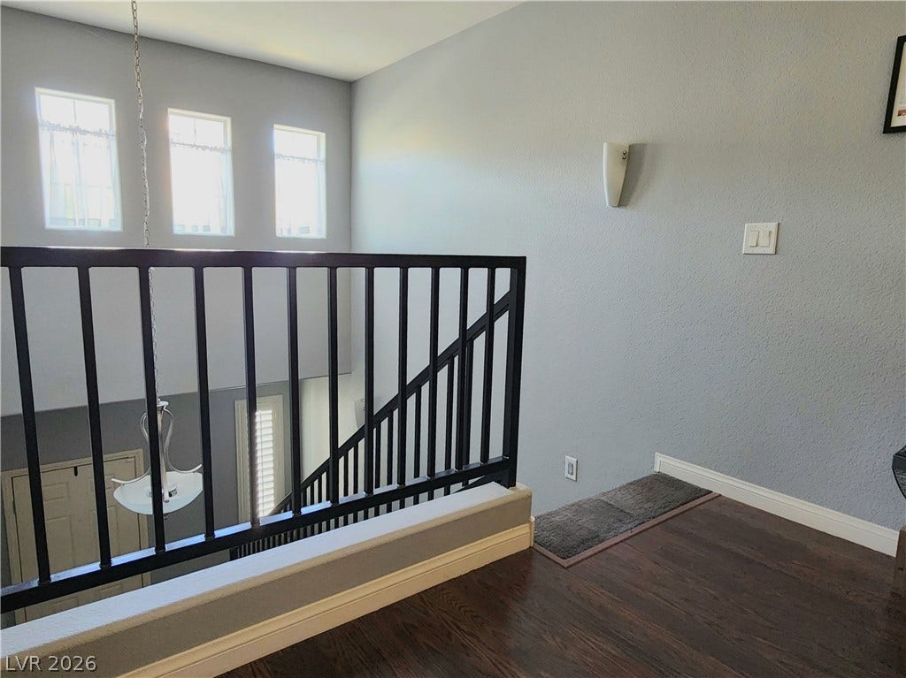 10549 Gibbous Moon Drive, Las Vegas, NV 89129 Rich wood floors and a modern metal railing frame this airy upper-level landing.