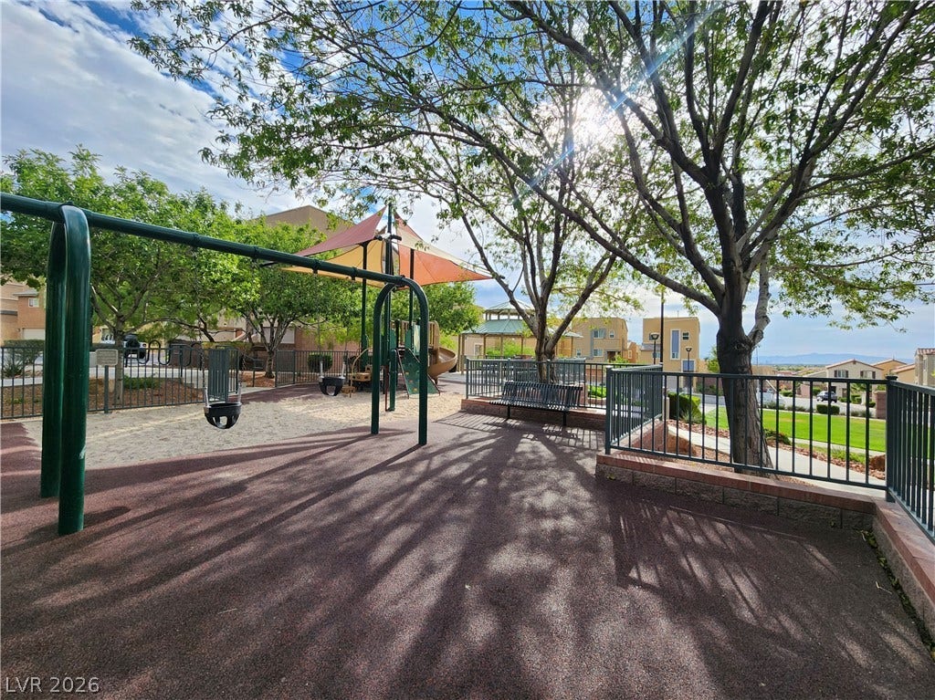 10549 Gibbous Moon Drive, Las Vegas, NV 89129 Mature trees shade a community playground complete with swings, play structures, and protective safety surfacing.