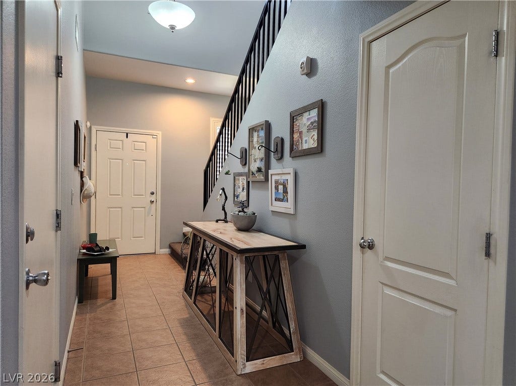 10549 Gibbous Moon Drive, Las Vegas, NV 89129 Tiled flooring and a modern staircase define this welcoming entry hall.