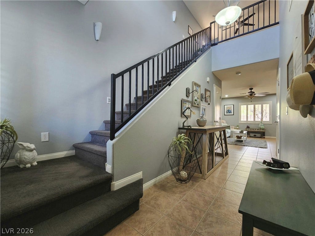 10549 Gibbous Moon Drive, Las Vegas, NV 89129 A spacious entry foyer leads past carpeted stairs to an open living area.