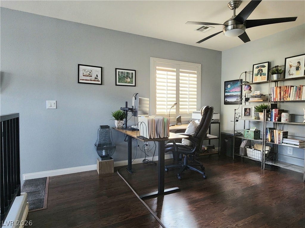 10549 Gibbous Moon Drive, Las Vegas, NV 89129 Gleaming wood floors and a bright window with shutters anchors this versatile home workspace.