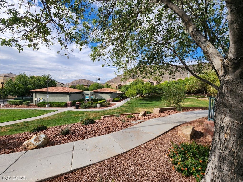 10549 Gibbous Moon Drive, Las Vegas, NV 89129 Paved walking paths wind through landscaped green spaces set against a mountainous backdrop.