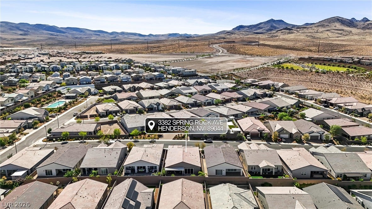 3382 Spring Rock Avenue, Henderson, NV 89044 Rugged desert mountains frame this modern residential neighborhood under clear blue skies.