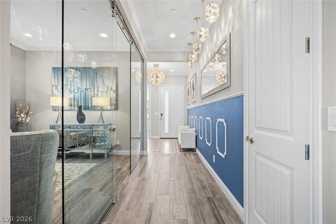 3382 Spring Rock Avenue, Henderson, NV 89044 Streamlined glass walls and warm wood-look flooring define this striking contemporary hallway entrance.