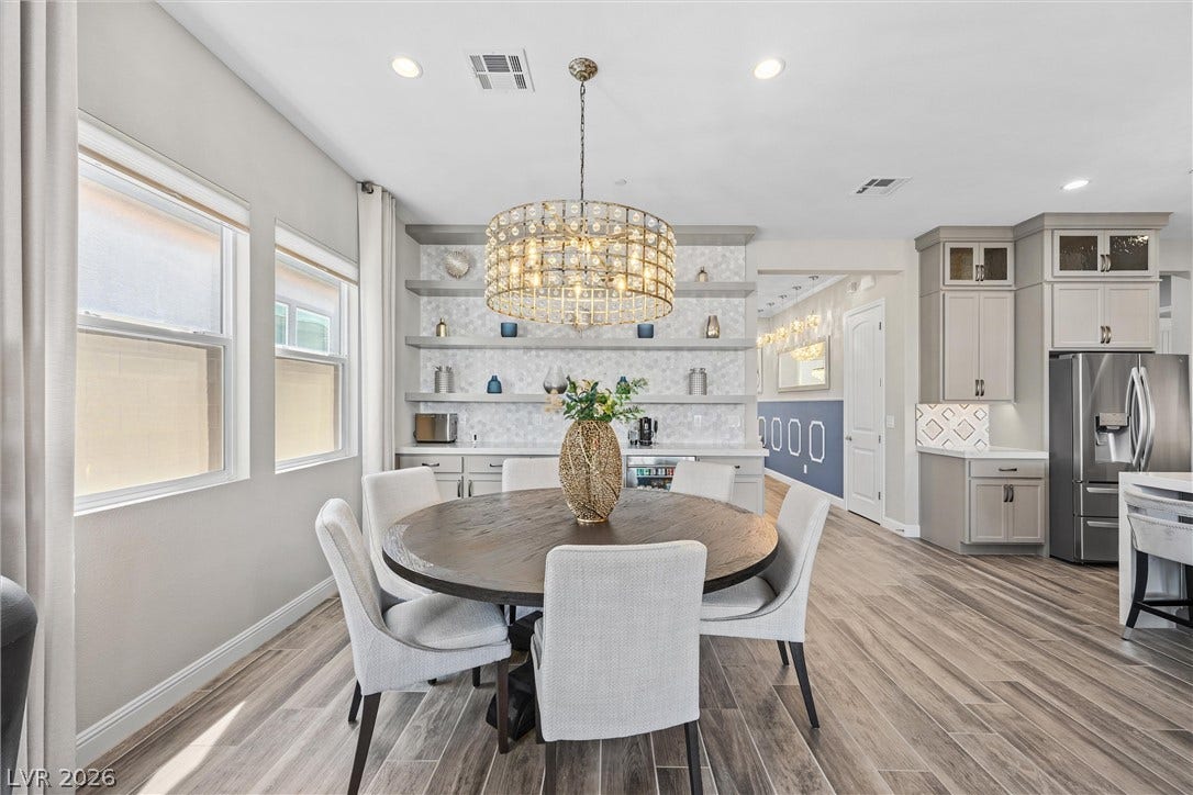 3382 Spring Rock Avenue, Henderson, NV 89044 Plank flooring runs beneath a casual dining area bordered by built-in shelving and the kitchen.