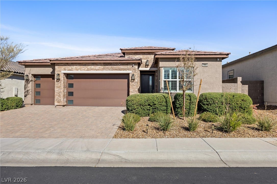 3382 Spring Rock Avenue, Henderson, NV 89044 Textured stone accents and a paved driveway enhance this modern single-level exterior design.