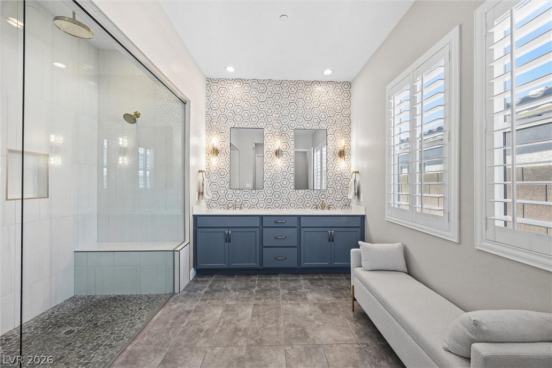 3382 Spring Rock Avenue, Henderson, NV 89044 A glass-enclosed walk-in shower and a double vanity define this modern primary bathroom.