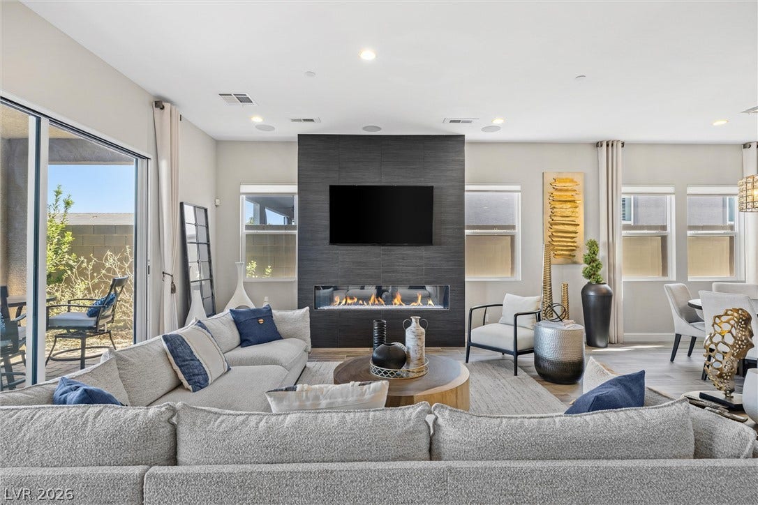 3382 Spring Rock Avenue, Henderson, NV 89044 An elegant modern fireplace anchors this airy living space with high ceilings and wood flooring.