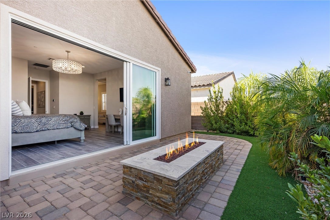 3382 Spring Rock Avenue, Henderson, NV 89044 A stone fire pit highlights the paved patio area situated just outside the master bedroom.