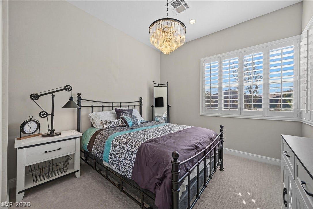 3382 Spring Rock Avenue, Henderson, NV 89044 High ceilings and plantation shutters elevate this comfortable bedroom with plush carpeting.