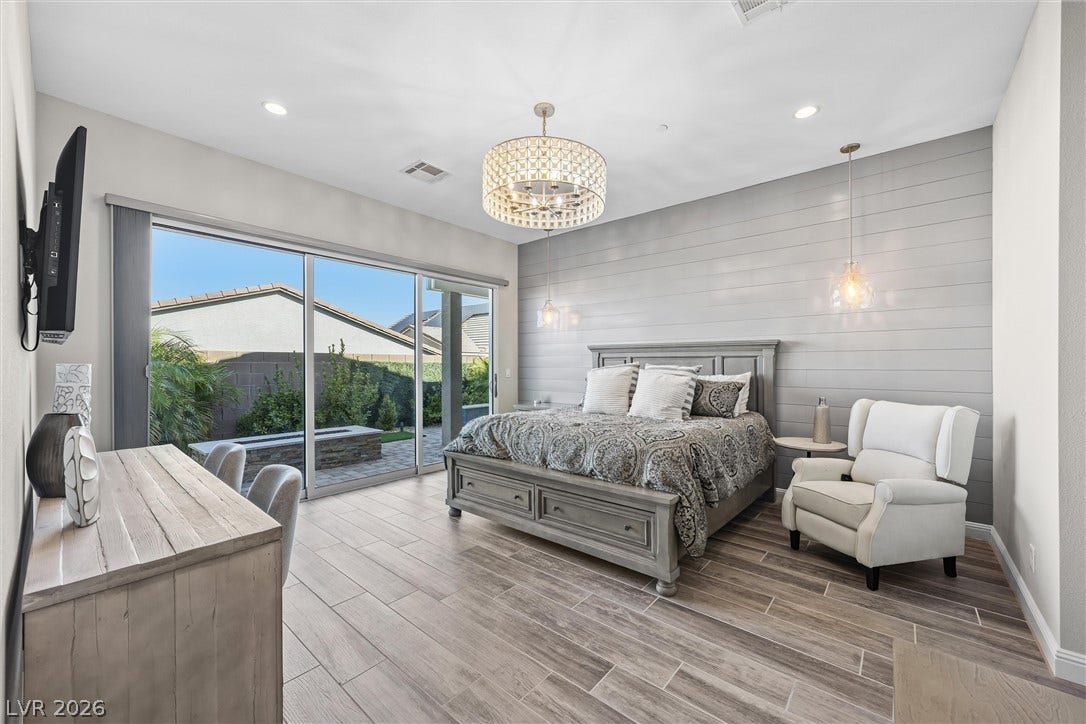 3382 Spring Rock Avenue, Henderson, NV 89044 A spacious bedroom with tile flooring and sliding glass doors opening to the patio.