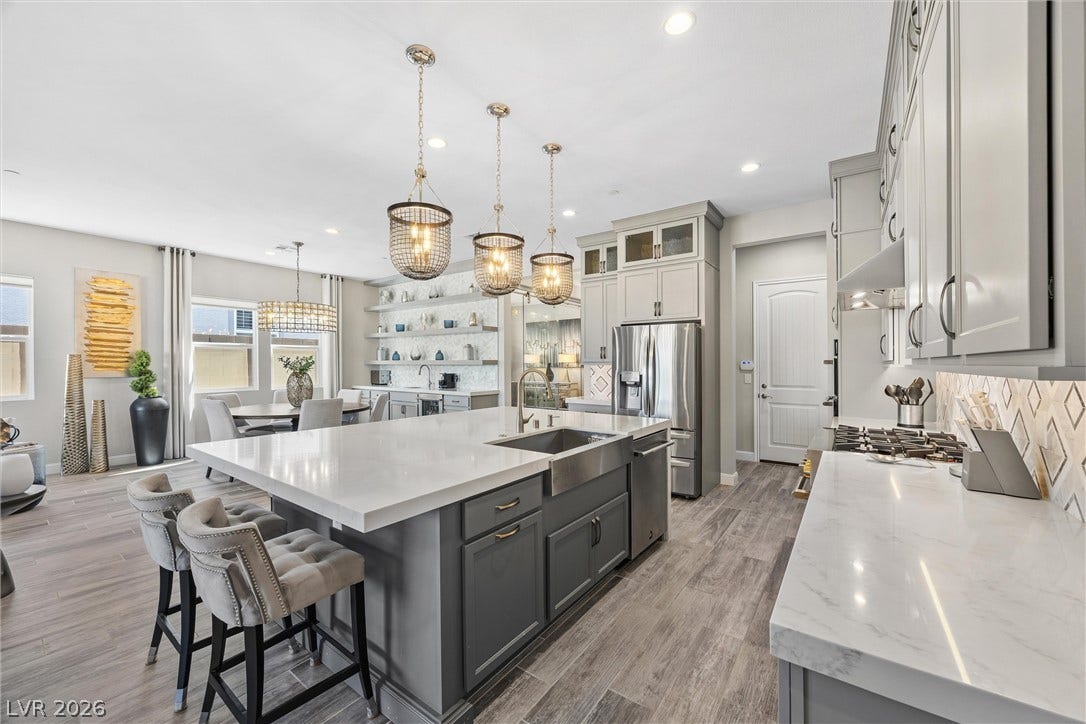3382 Spring Rock Avenue, Henderson, NV 89044 Polished stone countertops and sleek cabinetry elevate this modern open-concept kitchen.