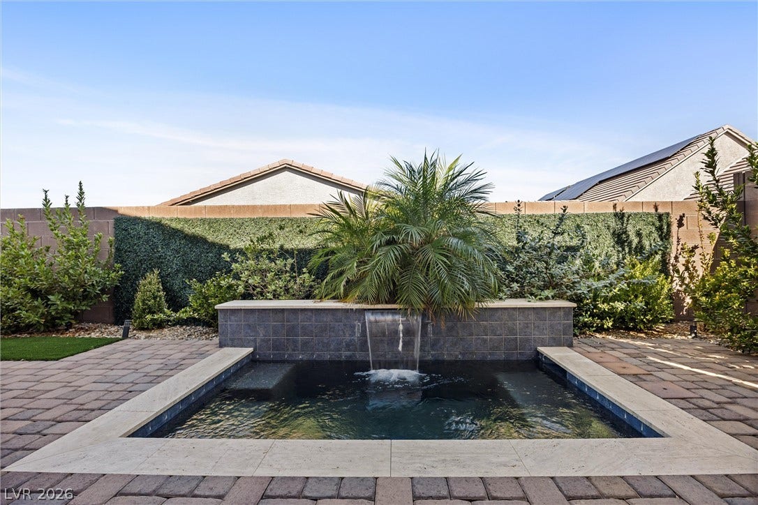 3382 Spring Rock Avenue, Henderson, NV 89044 An inviting backyard spa features stone pavers and a tranquil waterfall feature.