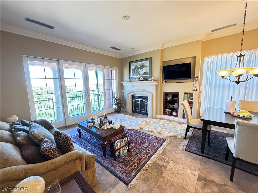 12 Via Visione, #204, Henderson, NV 89011 Stone tile flooring and a classic fireplace anchor this inviting living space.