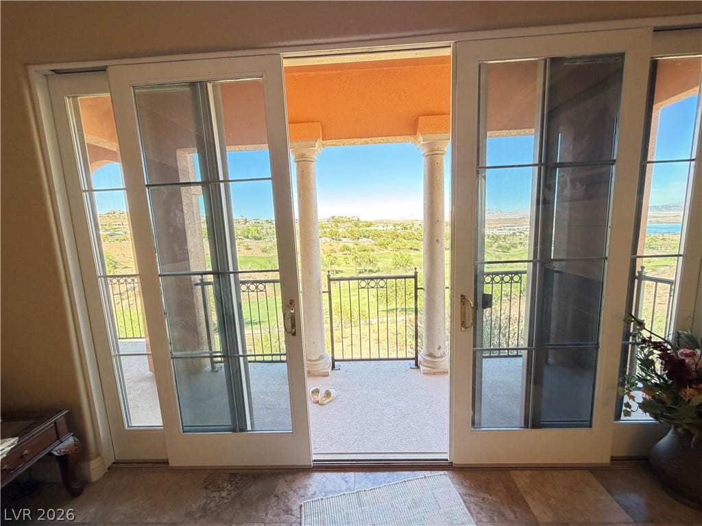 12 Via Visione, #204, Henderson, NV 89011 Grand sliding doors open directly to a scenic covered balcony with elegant stone columns.