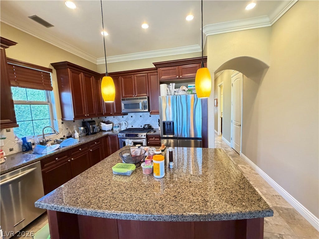 12 Via Visione, #204, Henderson, NV 89011 Gleaming granite countertops pair beautifully with rich wood cabinetry and professional-grade appliances.